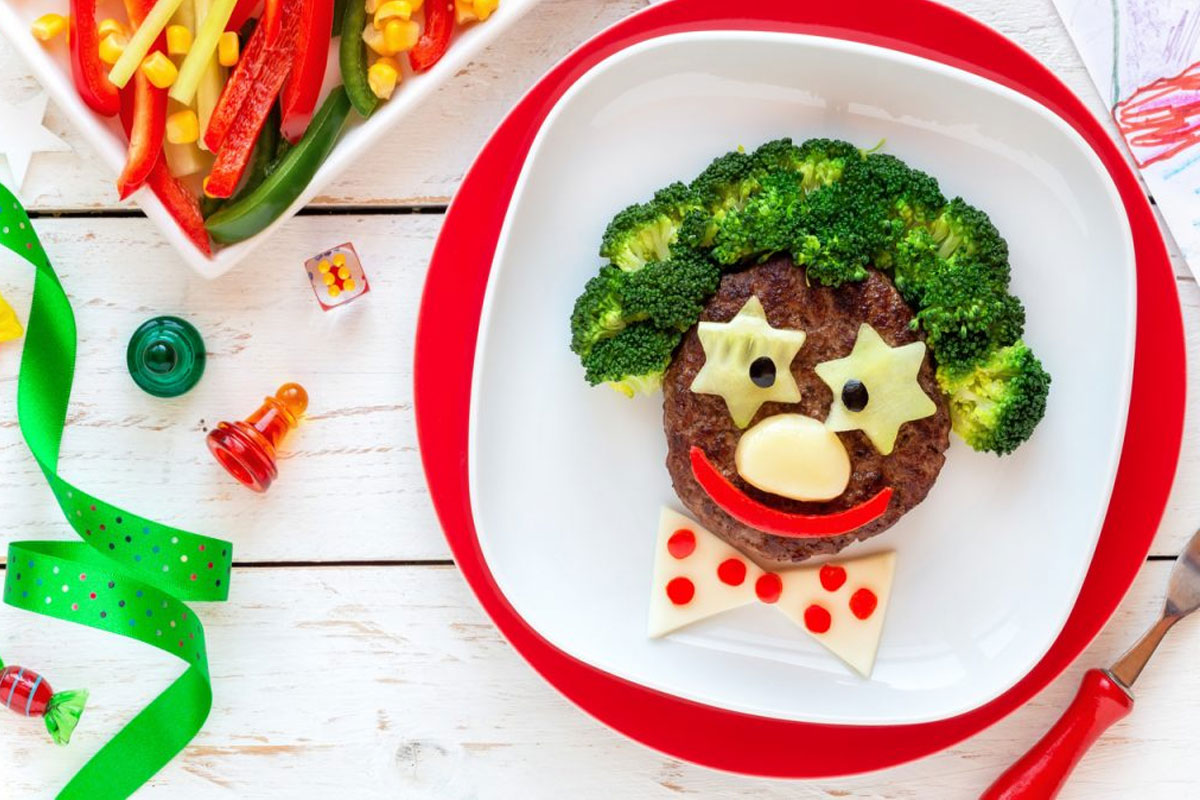 Imagem ilustrativa de uma refeição saudável para crianças, com frutas, vegetais, cereais e proteínas, representando os alimentos essenciais para o desenvolvimento infantil.